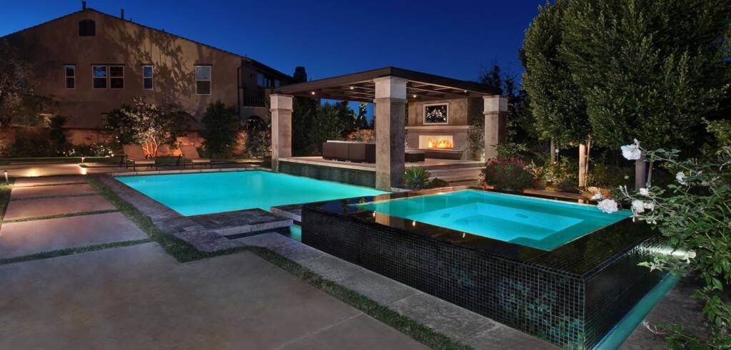 “Modern backyard with custom patio, pool, and fire feature designed by Altera Landscaping in Dana Point.”